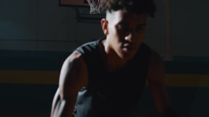 一名年轻职业男球员的电影慢动作特写镜头正在健身房用两个球练习篮球锻炼