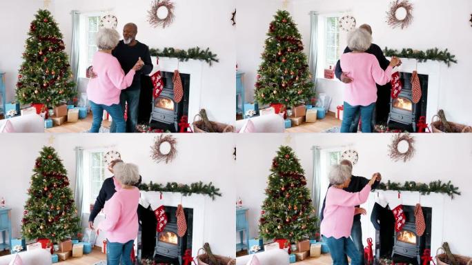 老年黑人夫妇在客厅跳舞的后视图，为圣诞节装饰，四分之三长度的视图，手持