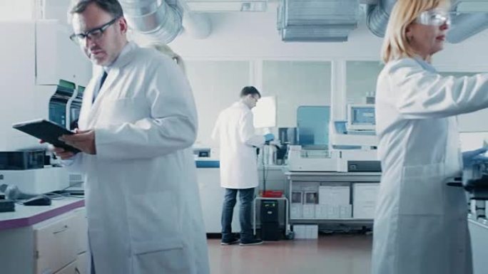 研究团队的科学家在制药实验室工作，他们使用现代医疗设备，计算机，分析血液和遗传物质样本。