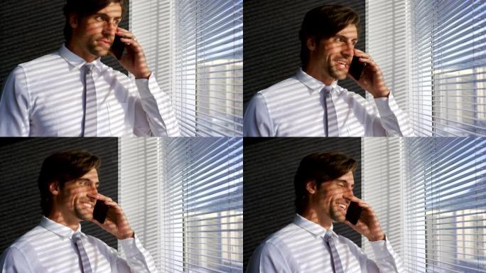 年轻的白人男性高管在现代办公室4k上用手机交谈的前视图
