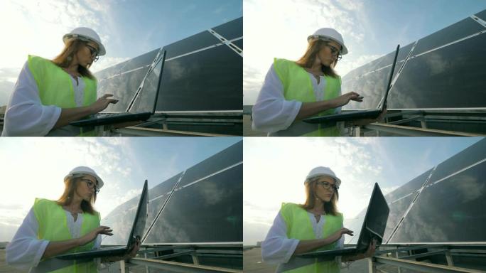 好看的女人在靠近太阳能建筑时正在操作笔记本电脑