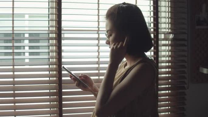 女人在家使用智能手机放松和听音乐。
