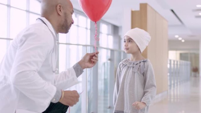 黑人男性医生为儿童癌症患者提供气球