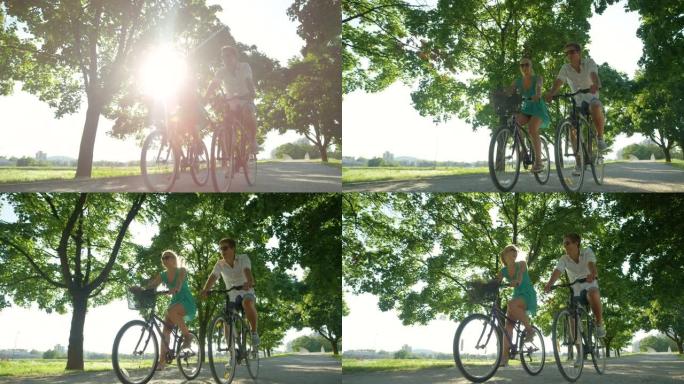 低角度: 阳光照射在公园周围骑自行车的快乐旅游夫妇身上