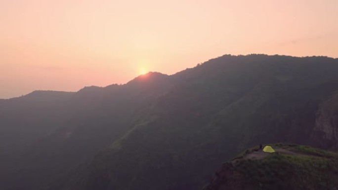 4k分辨率鸟瞰图旅游摄影师在悬崖和美丽的山上露营和帐篷，泰国富图伯克旅行冒险概念