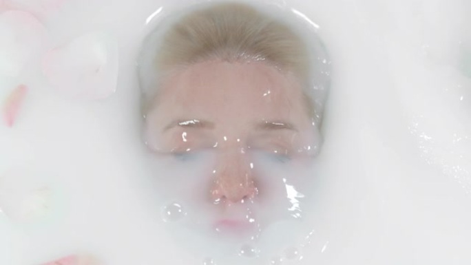 超级SLO MO女人在放松的浴缸里泡头