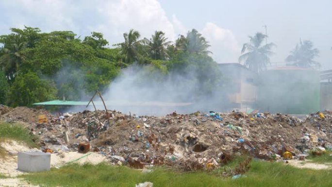 充满垃圾的垃圾填埋场正在热带森林中部燃烧废物。