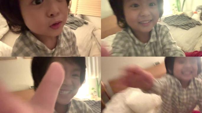 亚洲家庭与一个快乐的儿子在床上玩耍