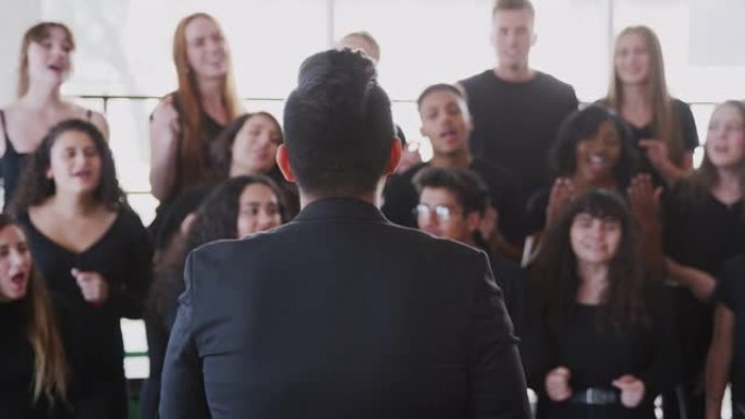 男女学生在表演艺术学校与老师合唱唱歌