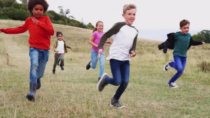 一群儿童在户外活动野营下奔跑的前视图
