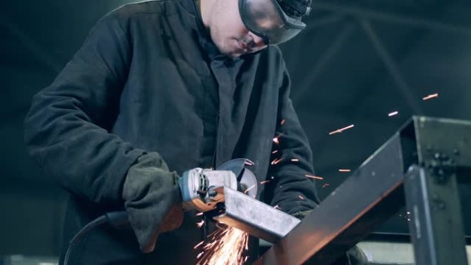 男性焊工正在用旋转锯切割钢