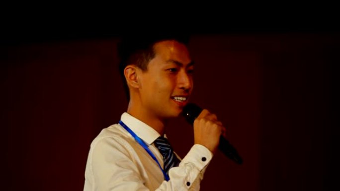 年轻的亚洲商人在4k礼堂的商业研讨会上发言