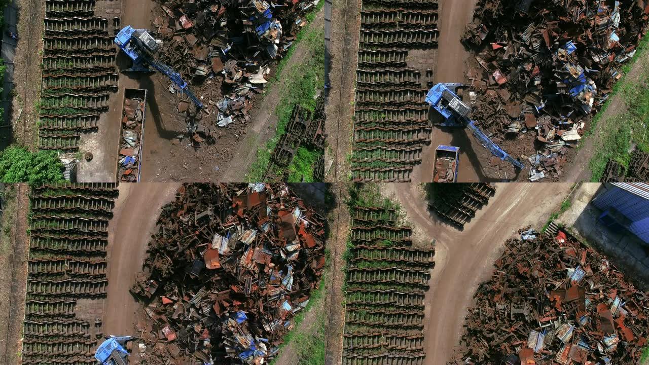垃圾场忙碌的一天。机械爪滴金属废料。鸟瞰图