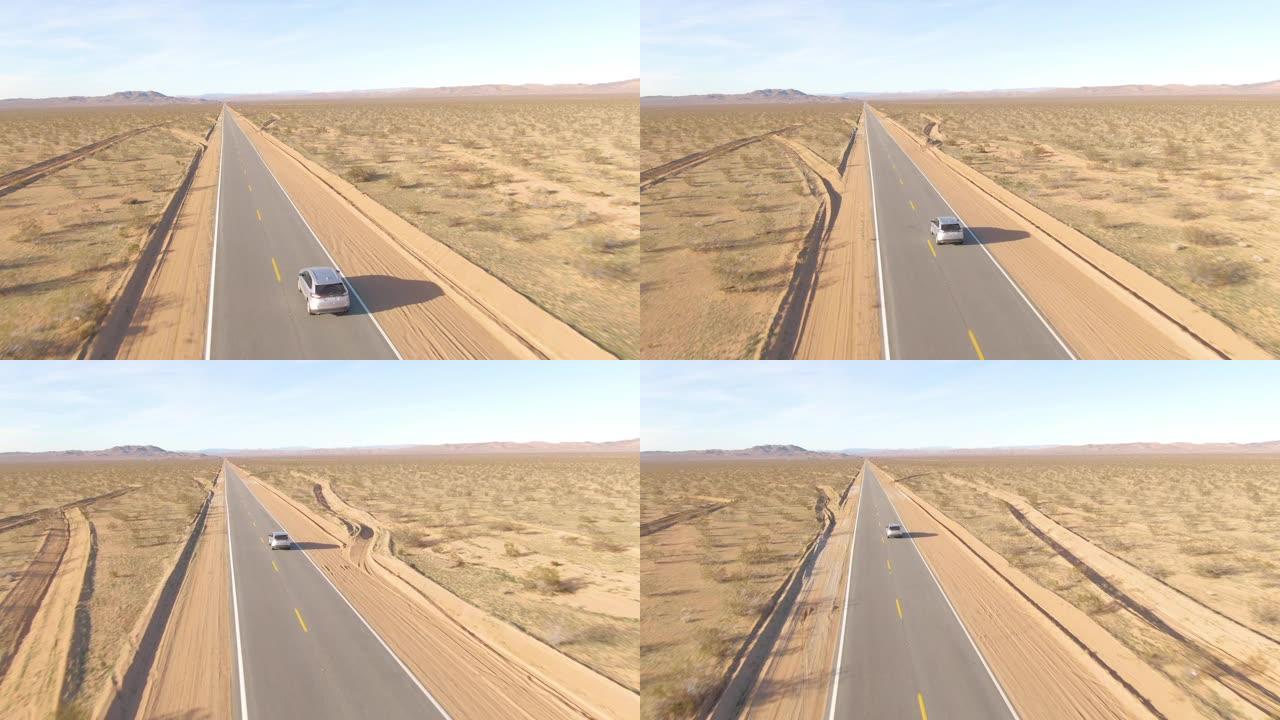 空中: 穿过崎Mojave的莫哈韦沙漠时，在银色SUV后面飞行。