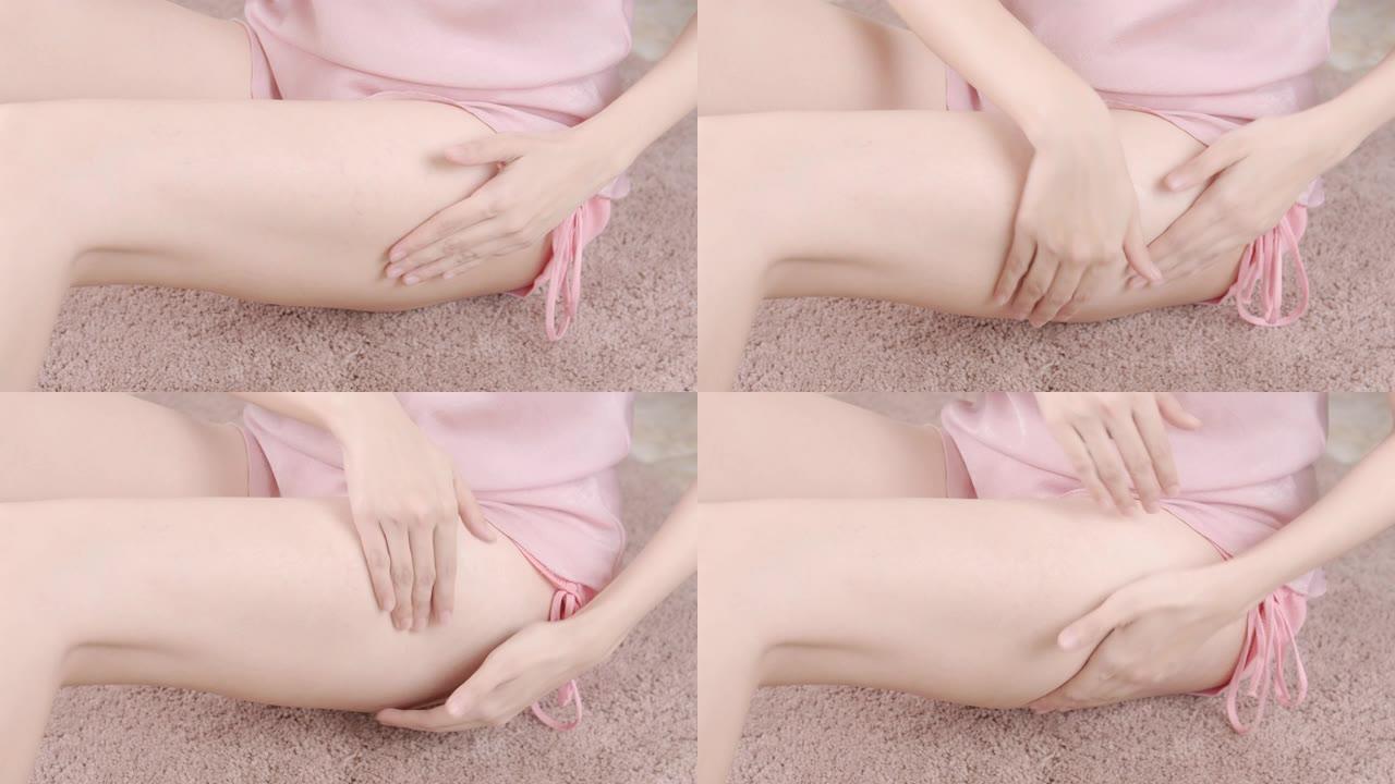 成年亚洲女孩将抗脂肪霜或血清放在腿上。身体护理和抗衰老概念