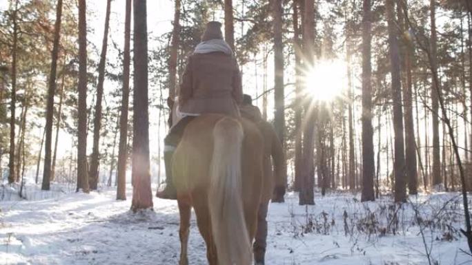 夫妇在冬季森林骑马