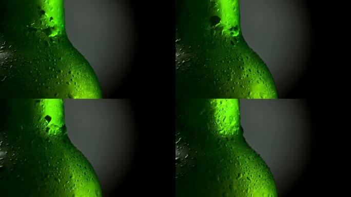 带水滴的冷啤酒绿色瓶子的特写镜头。旋转360，黑色背景。UHD, 4K