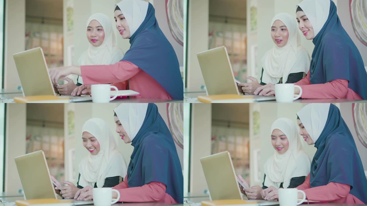 两个穆斯林人在工作空间用笔记本电脑工作和讨论。