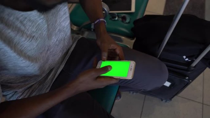 黑人在机场休息室看着他的智能手机屏幕-色度键