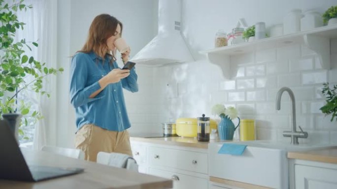 穿着牛仔裤衬衫和棕色裤子的年轻女性正在厨房里使用她的智能手机。她在现代厨房里跳舞，生活方式健康。快乐
