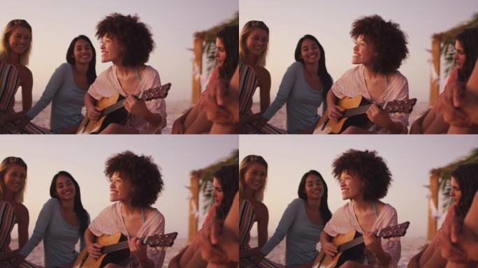 混血女人在海滩上为她的朋友弹吉他