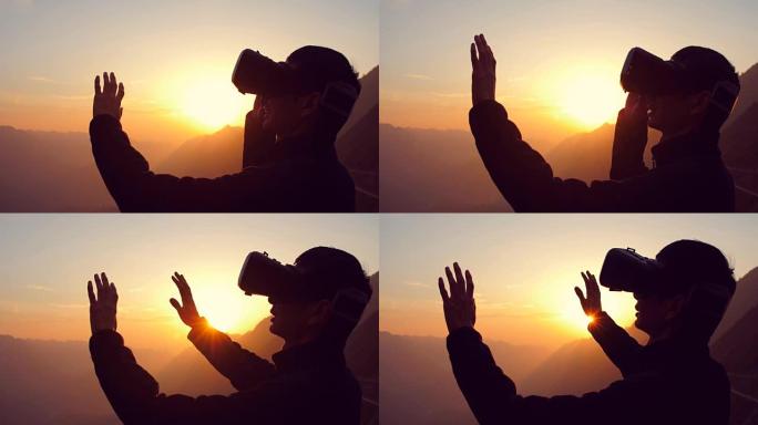 男子使用虚拟现实耳机与山日落背景