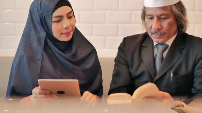 亚洲穆斯林商业团队在使用平板电脑的咖啡馆开会。商务人员会议伙伴关系。商务顾问在会议期间分析公司的财务