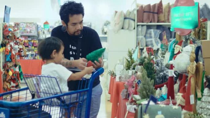 亚洲父亲正在超市和儿子一起购物过圣诞节。