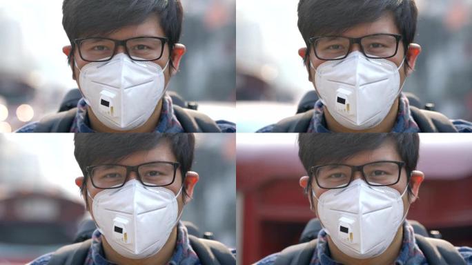 CU手持亚洲男子戴空气污染面罩看相机