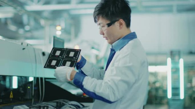 高科技工厂: 质量控制工程师检查电子印刷电路板是否损坏。在具有表面贴装拾取和放置技术的PCB的后台装