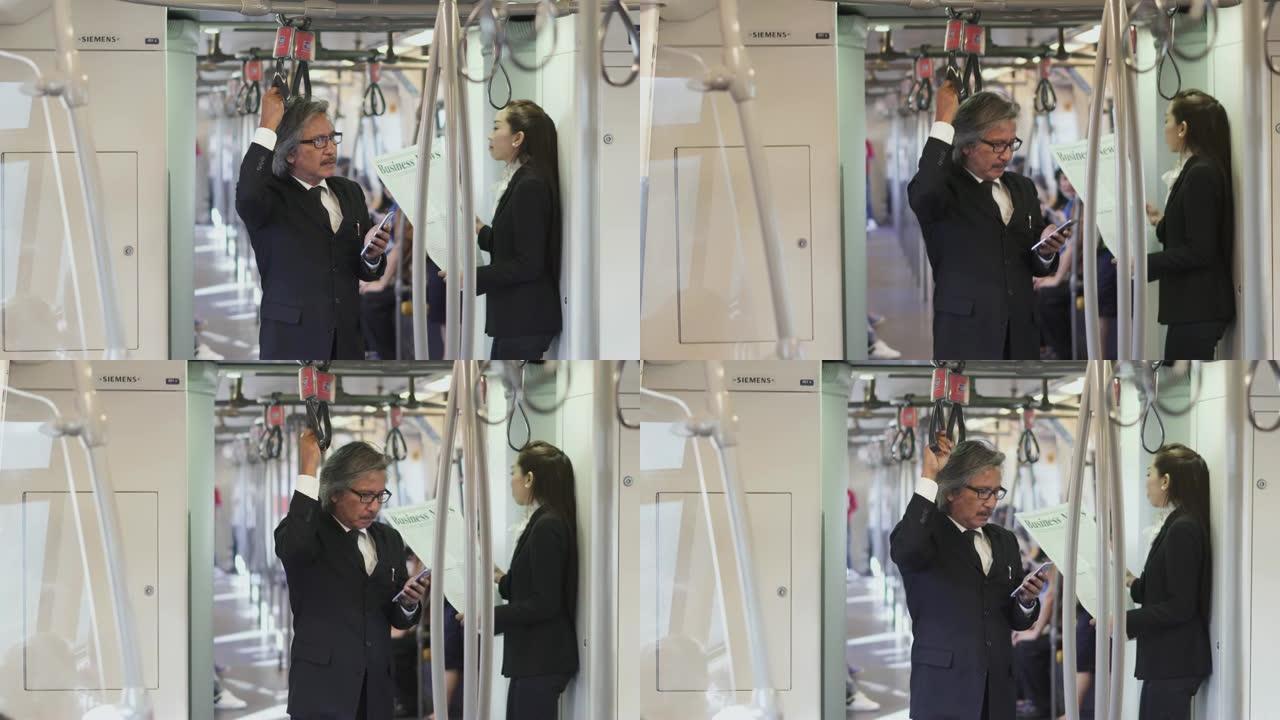 在地铁列车上使用智能手机的商人。