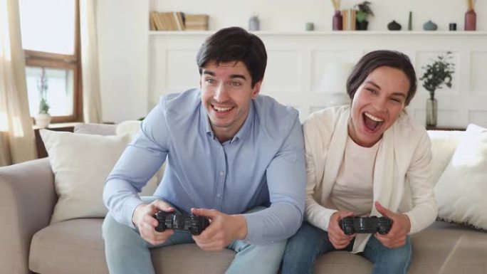快乐的男女朋友赢得电子游戏和拥抱