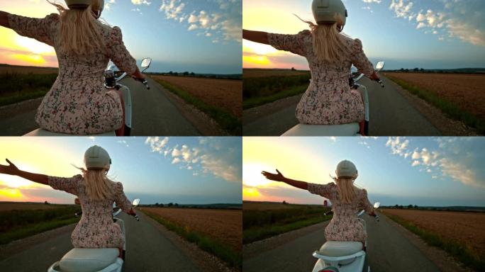 超级SLO MO欣喜若狂的女人在乡村路上骑着踏板车