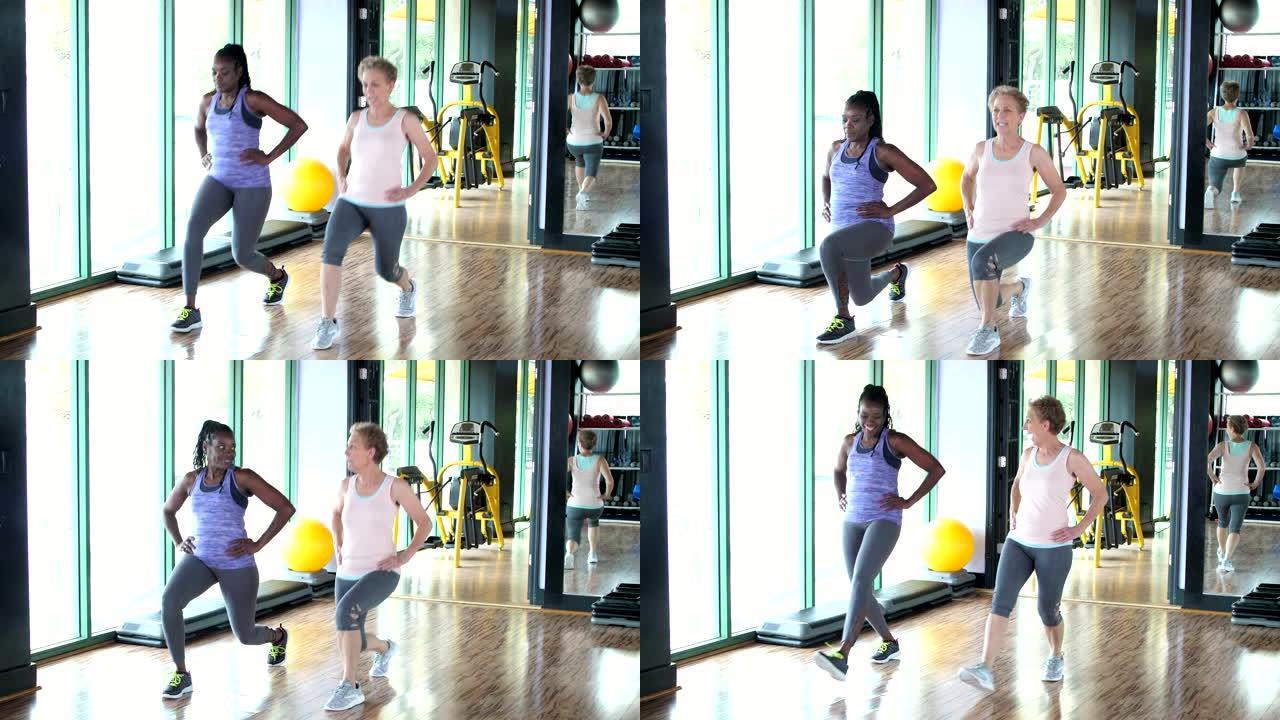 两个女人在健身房一起锻炼，弓步