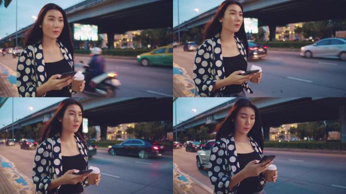 亚洲女商人晚上在城市街道上用智能手机发短信。