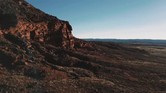 无人机在亚利桑那州巨大的悬崖和岩石旁飞行，令人难以置信的无尽广阔的阳光沙漠天际线开放空间。