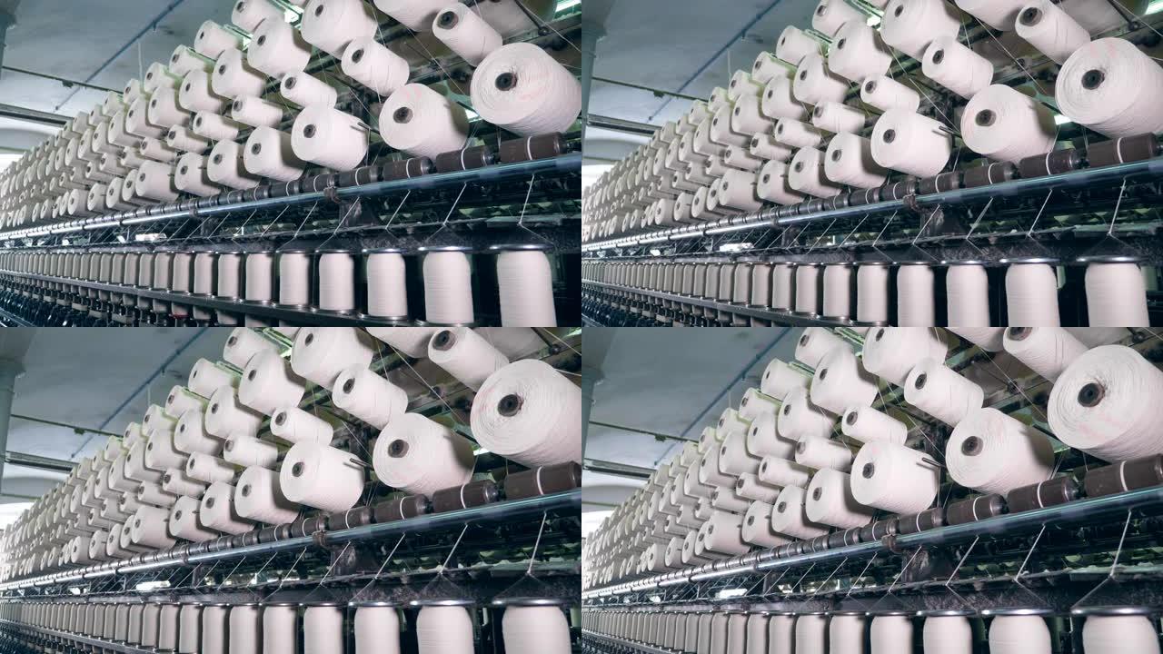 纺织织物的织机。在现代化的设施中，用白线旋转线轴。
