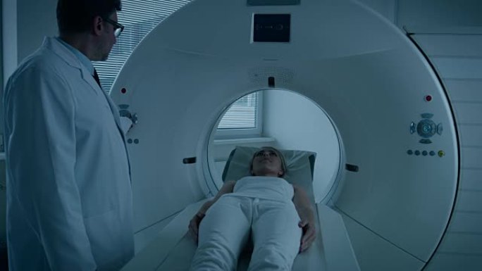 在医学实验室中，放射科医生对接受手术的女性患者进行MRI或CT或PET扫描。医生用先进的医疗技术进行