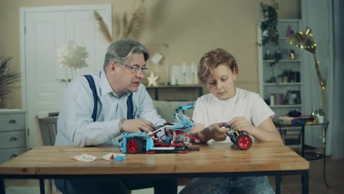 玩具车由一个男孩和他的祖父组装