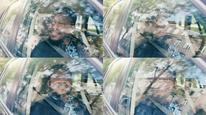 英俊的年轻黑人坐在汽车的乘客座位上，惊讶地看着窗外。郊区反映在窗户上。摄像机安装在移动汽车外部。