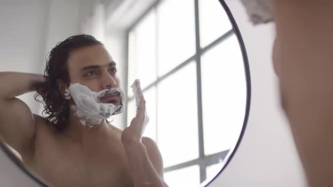 男子在浴室用剃须泡沫准备面部