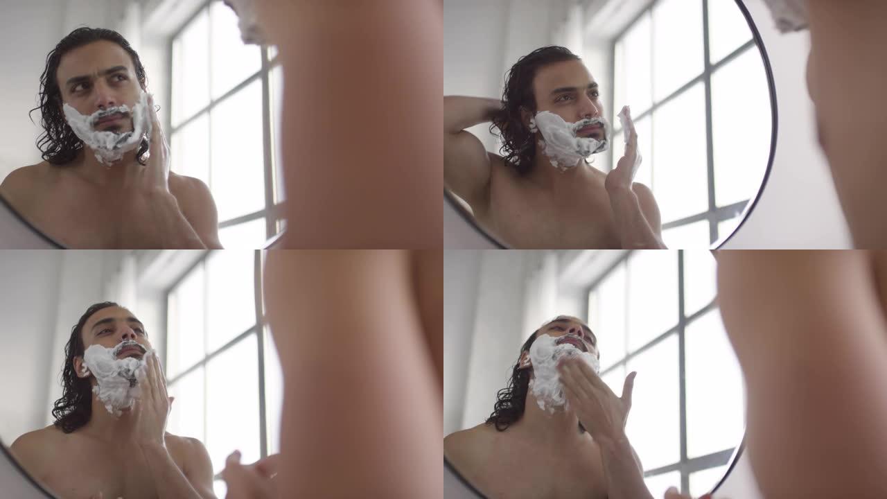 男子在浴室用剃须泡沫准备面部
