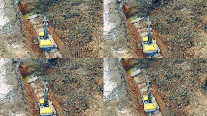 一台挖掘机在坑里移动沙子。