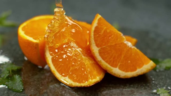 慢动作，微距: 美味的果冻在多汁的橙片上盘旋。
