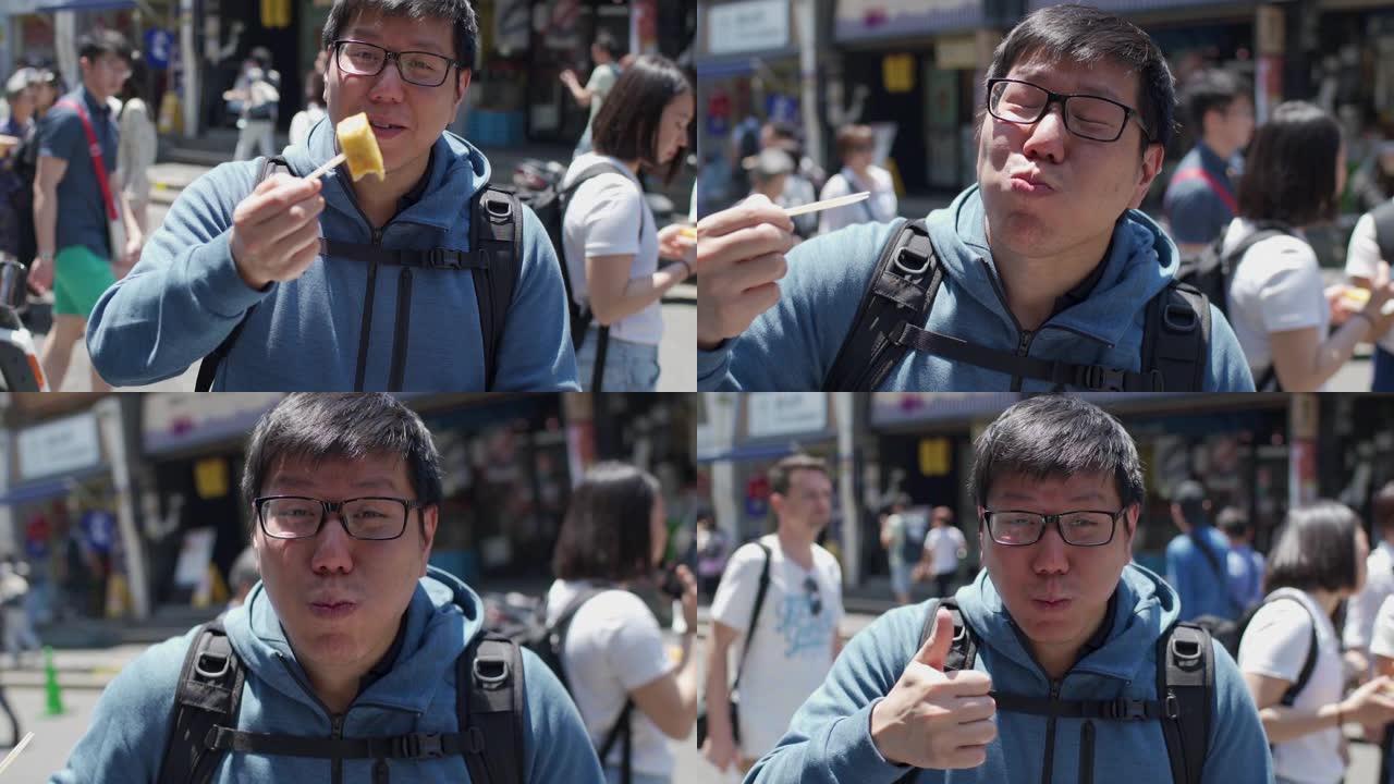 SLO MO亚洲旅游男子在日本东京街头食品市场吃日本Tamago鸡蛋