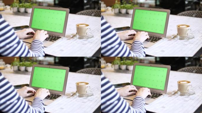 在带有绿屏的笔记本电脑上使用的特写女人