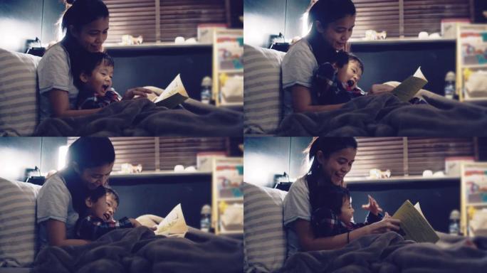 年轻的亚洲母亲读儿子的睡前故事