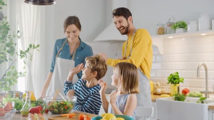 厨房: 四口之家一起烹饪健康晚餐。母亲，父亲，小男孩和女孩，准备沙拉，洗菜和切菜。可爱的孩子帮助他们