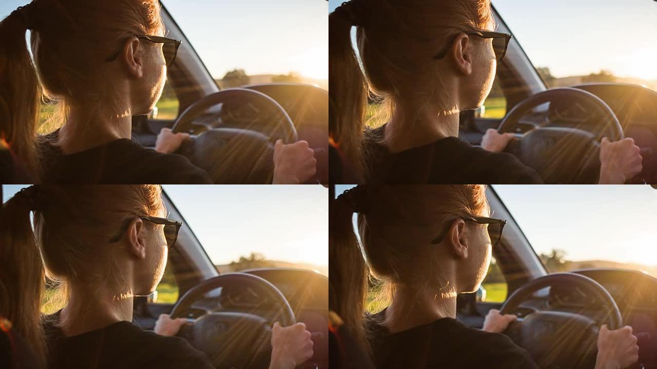 女人开车进入日落夕阳路上驾驶光芒