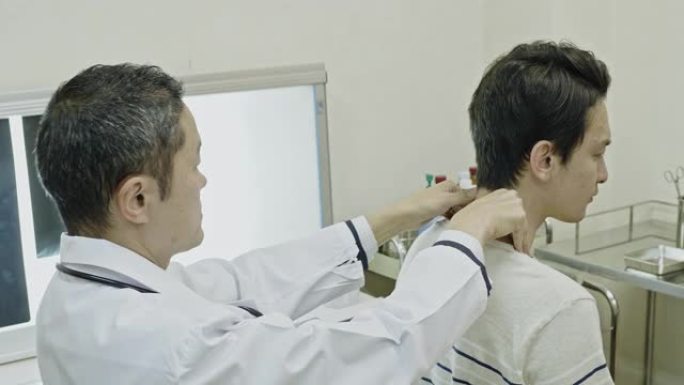 日本医生在医院检查患者的脖子和肩膀